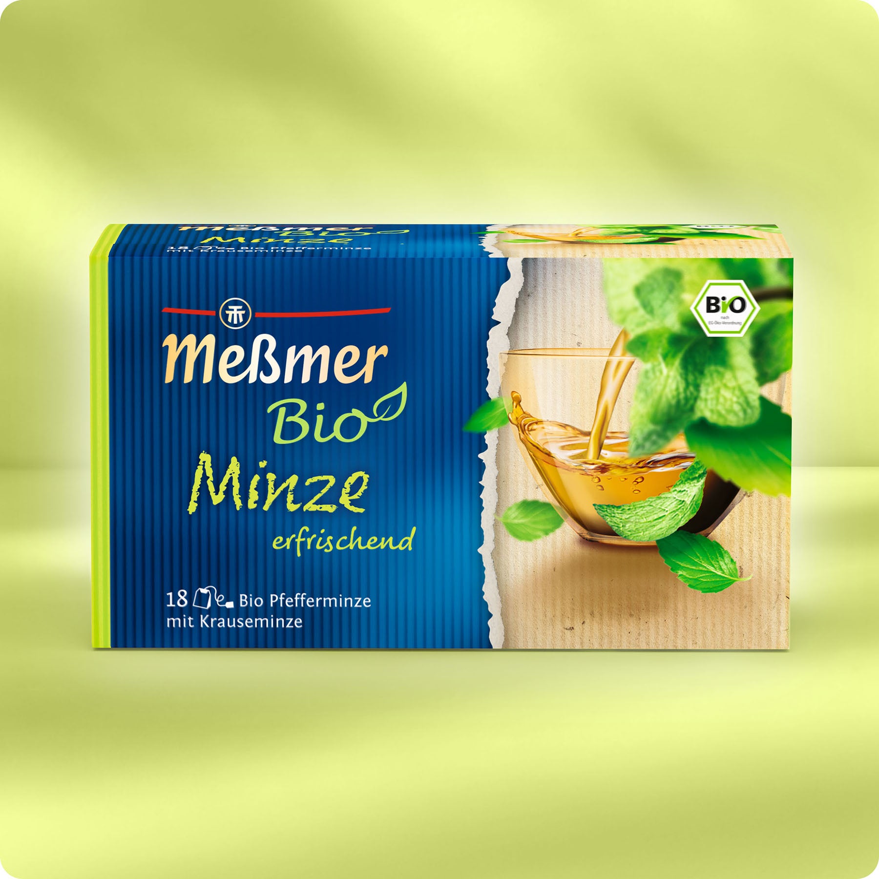 Eine Schachtel Meßmer DE Bio Minze Tee mit Minzblättern und einem Teeglas, in grün-blauer deutscher Verpackung, enthält 18 Teebeutel aus kontrolliert biologischem Anbau.