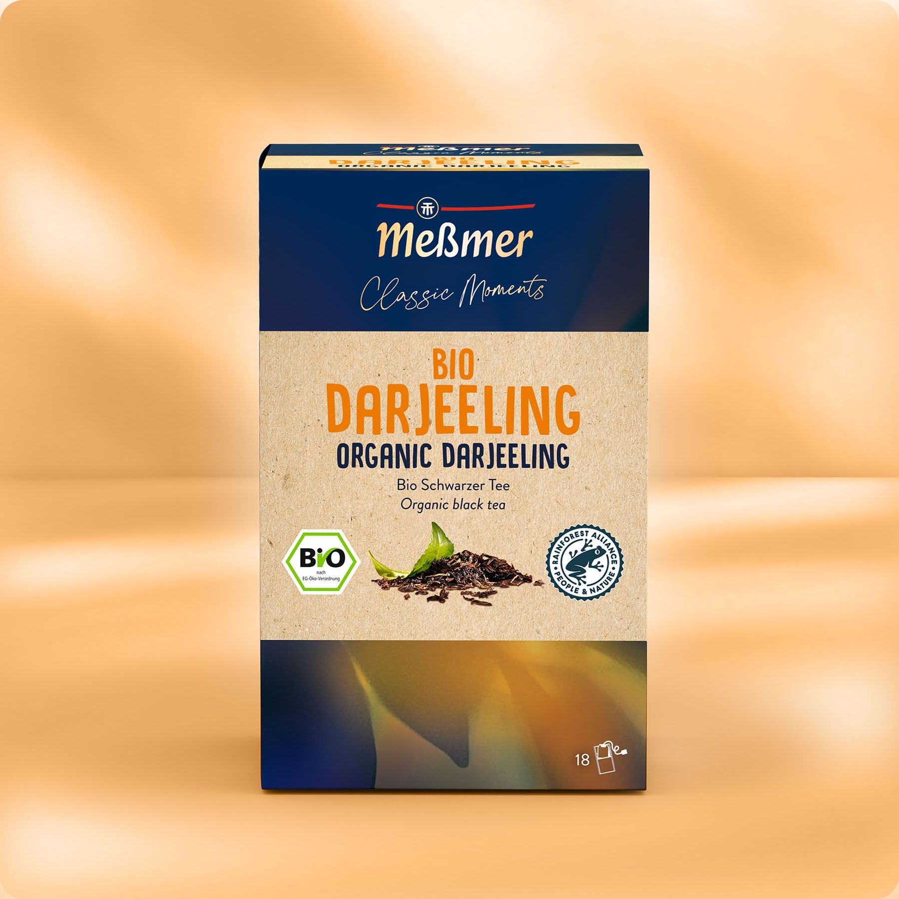 Eine Schachtel Meßmer DE Bio Darjeeling ist beige und dunkelblau verpackt, mit grünen Blättern und Zertifizierungslogos. Sie enthält 18 lose Teebeutel Darjeeling-Schwarztee - ideal für Fans von Mischungen im Stil des Englischen Frühstücks.