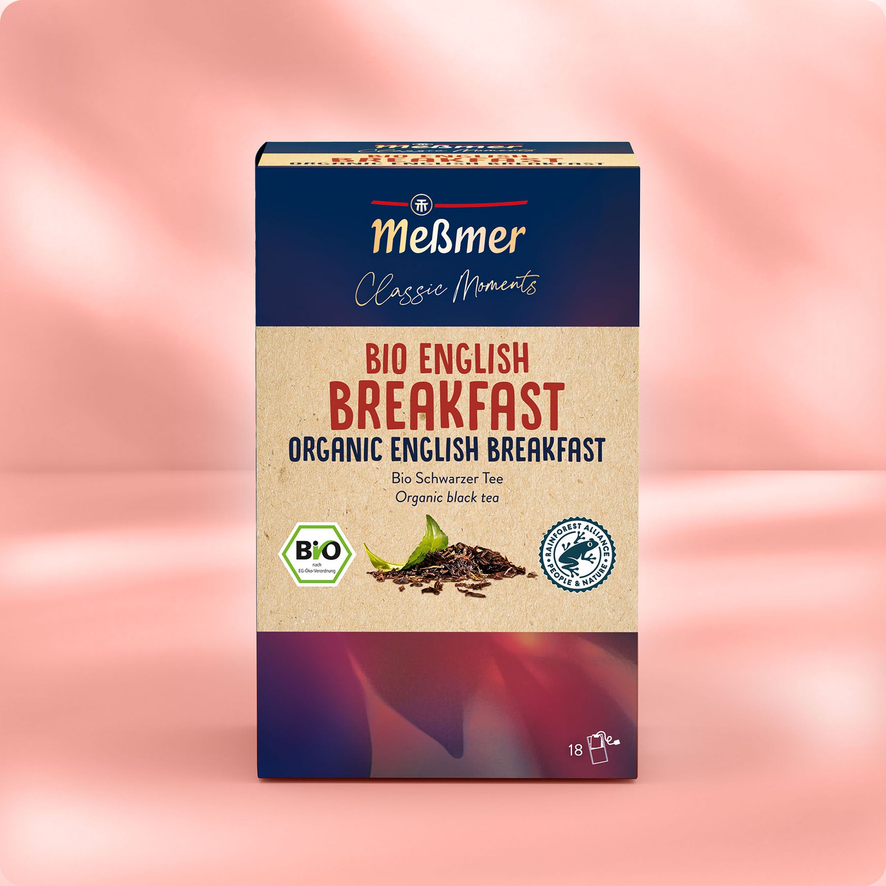 Eine Schachtel Meßmer DE Bio English Breakfast-Tee in beigefarbener und dunkelblauer Verpackung mit deutschem und englischem Text, einem Bild des Teeblatts und den Logos der Bio-Zertifizierung.