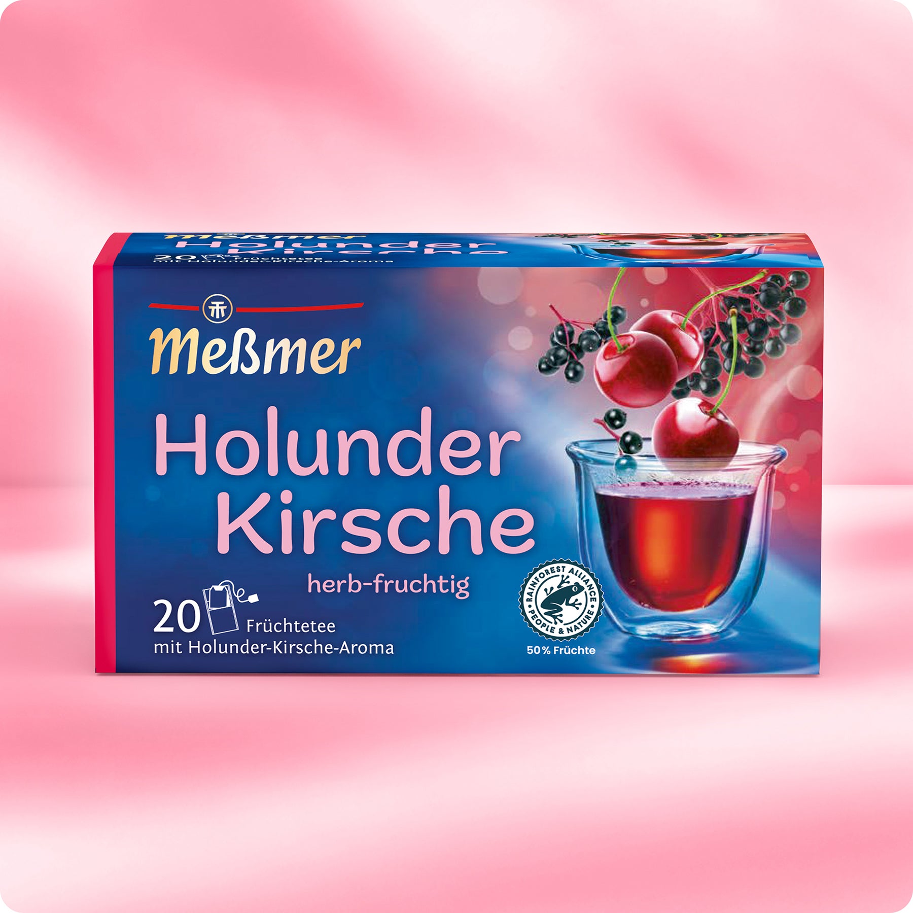 Eine Schachtel Meßmer DE Holunder-Kirsche zeigt auf der Vorderseite ein Glas roten Tee mit Holunderbeeren und Kirschen. Die rosa-blaue Schachtel enthält 20 Früchteteebeutel mit Holunder-Kirsch-Geschmack.
