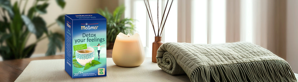 Meßmer Detox your feelings Tee in entspannter Selfcare-Atmosphäre mit Duftstäbchen, Kerze und kuscheliger Decke – Teile dieses Fotos wurden mit KI ergänzt.